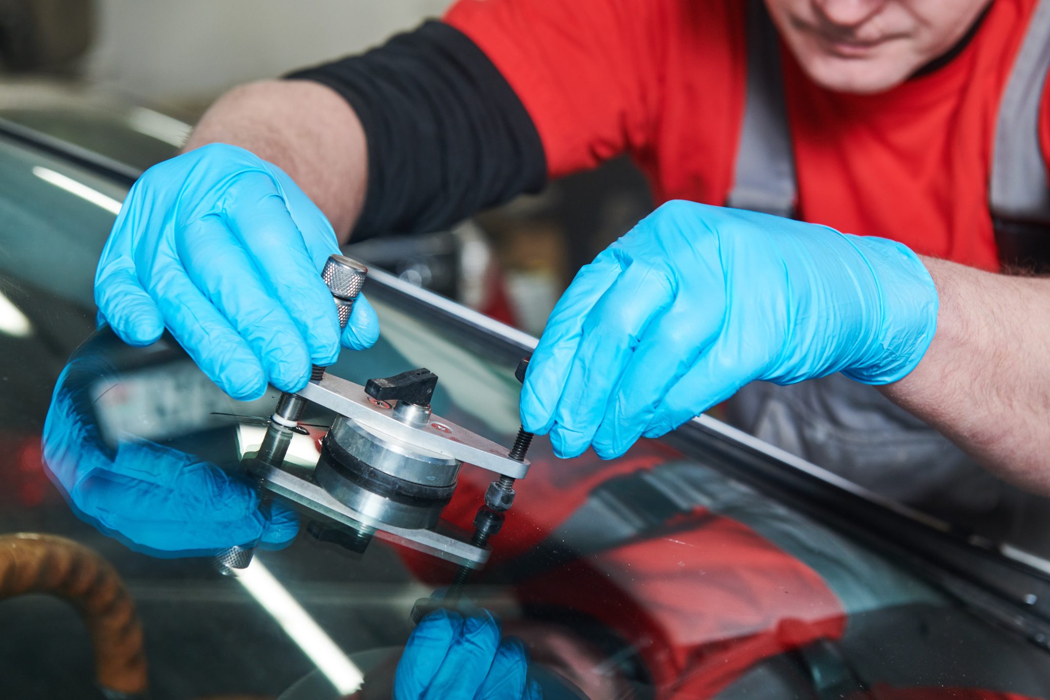 Dodge Journey windshield replacement in Phoenix, Arizona - technician inspecting a chip in automotive glass