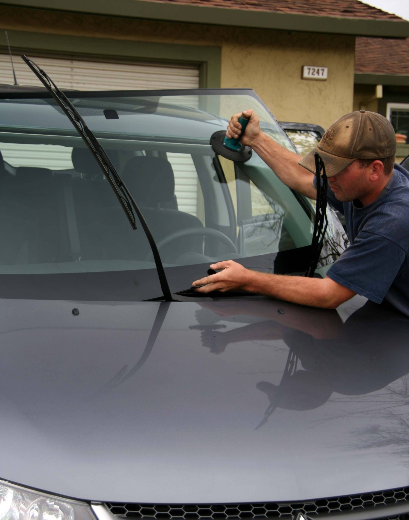 Chrysler 200 windshield replacement in Phoenix, Arizona - auto glass professional working beside a vehicle